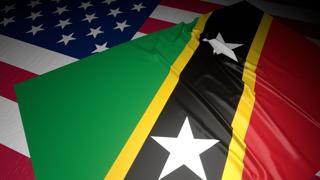 Saint-Kitts-and-Nevis National Flag, A flag placed on top of an American flag on a desk in a dark space