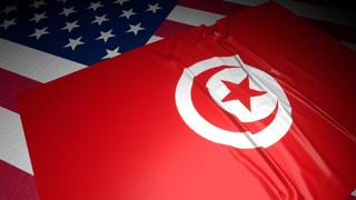 Tunisia National Flag, A flag placed on top of an American flag on a desk in a dark space