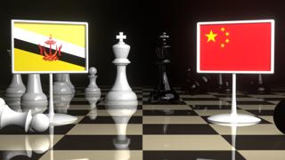 Brunei National Flag, The national flag on a chessboard with the Japanese flag in the background