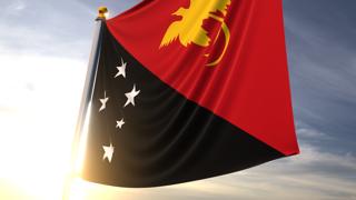 파푸아뉴기니 국기, 어두운 파란색 하늘을 배경으로 가까이에서 보이는 펄럭이는 국기와 국기봉